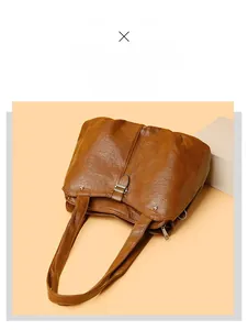 Detail view of brown tote bag featuring wrinkled leather texture and metal buckle accent