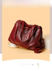 Detail of burgundy PU leather tote bag featuring wrinkled texture and silver buckle