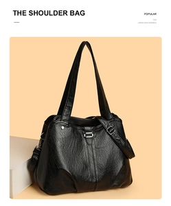 Detail of the black tote bag showing its wrinkled faux leather texture and silver buckle