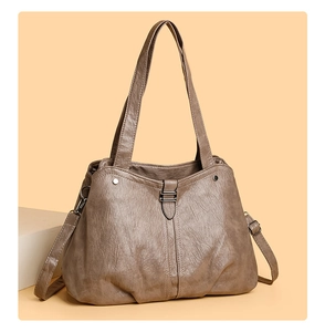 Detail view of large tote bag in dark beige pebbled leather with adjustable straps