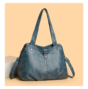 Detail of deep blue tote bag showing wrinkled leather texture and adjustable strap buckles