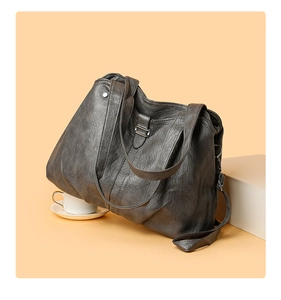 Detail of dark grey tote bag featuring soft leather texture and adjustable shoulder strap