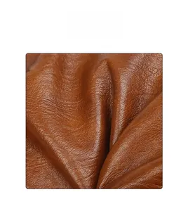 Close-up of high-quality brown leather fabric showing natural lychee grain and soft texture