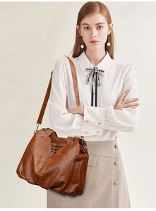 Detail of brown faux leather tote bag with lychee texture and silver metal hardware