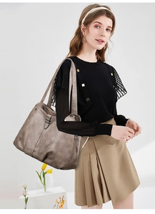 Close-up of a large vintage grey-brown tote bag with metallic texture and buckle detail