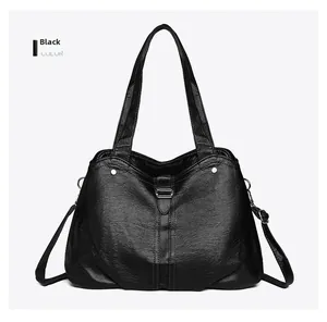 Detail view of the black tote bag showing metal hardware and pebble grain leather texture