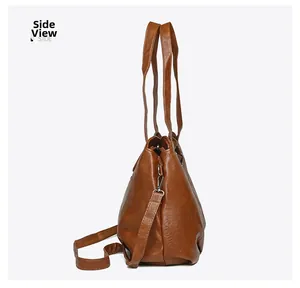 Side view of brown leather tote bag with litchi texture and silver zipper details
