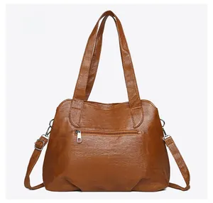 Detail view of the brown leather tote bag back with a silver zipper pocket and long strap