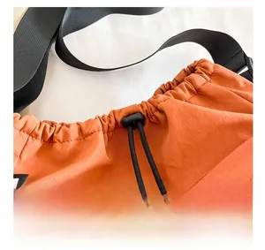 Detail shot of the orange nylon drawstring closure with a black plastic cord lock