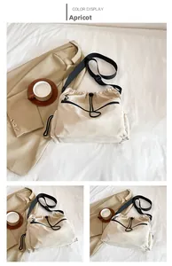 Detail of apricot nylon bucket bag with drawstring closure and adjustable wide strap