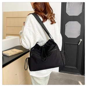 Detail of nylon bucket bag with adjustable wide strap and drawstring closure features