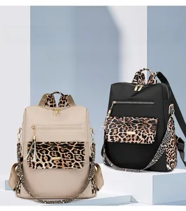 Detail of fashion leopard print backpacks in beige and black with stylish gold metal accents