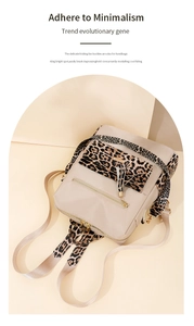 Close-up of beige nylon backpack featuring leopard print straps and a gold tassel charm