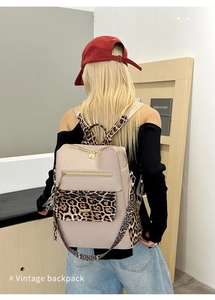 Detail of vintage beige nylon backpack with leopard print straps and golden hardware zippers