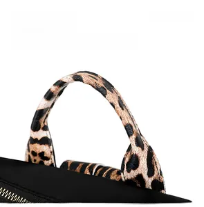 Detail of leopard print webbing handle and gold metal zipper on a black fashion backpack