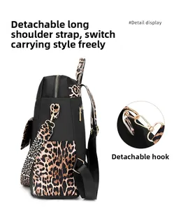 Detail of leopard print strap with gold metal hook on a black nylon backpack
