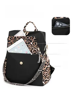 Detail display of black backpack showing multiple storage pockets and leopard print accents