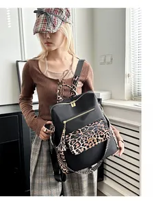Detailed view of women's leopard print anti-theft backpack with gold zippers and tassels
