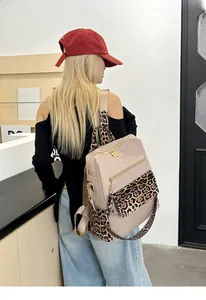 Detail of leopard print wide straps and gold zippers on high-capacity nylon backpack
