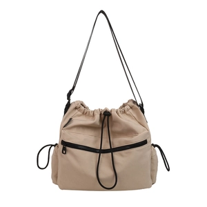 Khaki nylon drawstring bucket bag with black zipper pocket and adjustable strap