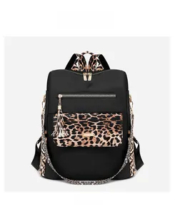 Front view of leopard print nylon backpack with gold zippers and tassel detail