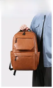 Detailed view of brown PU leather men's backpack with textured surface and double zippers