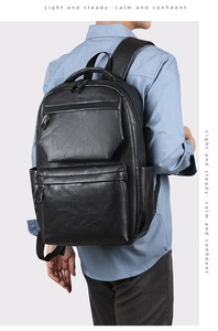 Detail view of the black PU leather backpack showing layered zippered front pockets