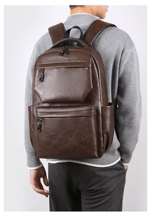 Detail view of a vintage dark brown PU leather travel backpack with multiple zip pockets