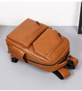 Close-up of vintage brown PU leather backpack with multiple zipper compartments and side pockets