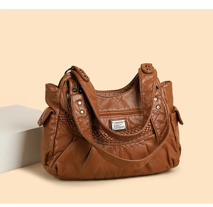 Detail of brown soft leather shoulder bag with zipper pocket and metal brand logo