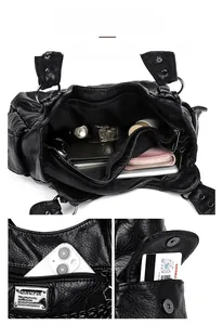 Detailed view of black faux leather bag interior with multiple zippered compartments and storage