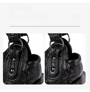 Detail view of black soft leather handbag showing metal rings and silver rivet accents