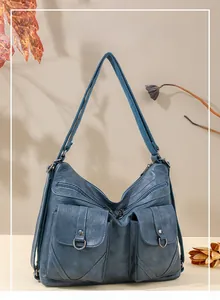Detail of blue faux leather tote with functional pockets and textured finish