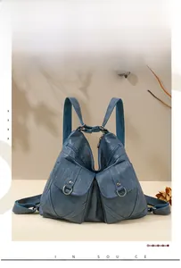 Close-up of vintage blue soft leather backpack with textured pockets and metal buckles