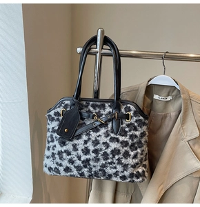 Détail du sac à main en fausse fourrure léopard avec lanières en cuir et boucles dorées