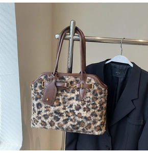 Détail du sac cabas en peluche imprimé léopard avec anses en cuir marron et métal doré