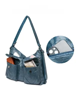 Detail view of large blue vintage PU leather tote showing multiple storage pockets