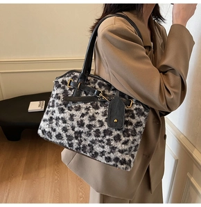 Détail d'un sac cabas en fausse fourrure léopard avec poignées en cuir noir et boucles