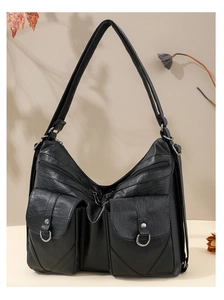 Detail of black faux leather tote with textured finish and silver buckle pockets