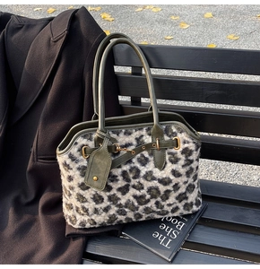 Détail du cabas en fausse fourrure léopard avec anses en cuir olive et boucle en métal doré