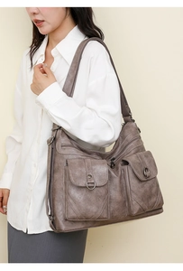 Detail view of large taupe PU leather tote bag with multi-pocket and metal zipper design