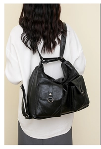 Detail view of black vintage soft leather shoulder bag with multiple functional pockets