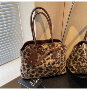 Détail d'un sac cabas léopard en fausse fourrure avec poignées en cuir et boucle dorée