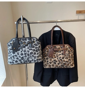 Détail de sacs à main en fausse fourrure léopard avec boucles métal et anses en cuir