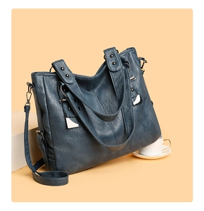 Detailed macro view of navy blue vintage faux leather texture and silver rivets on a tote