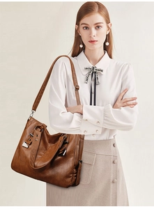 Close-up of brown leather tote bag with fine texture and adjustable shoulder strap