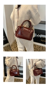Vue détaillée du sac Boston en cuir ciré bordeaux avec boucles dorées et sangle