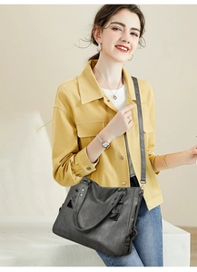 Detailed view of the dark grey soft leather tote bag with side pleats on a model