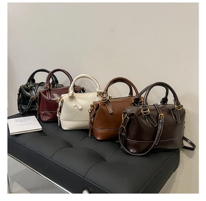 Cinq sacs Boston de différentes couleurs avec surpiqûres blanches et détails dorés