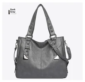 Detail view of dark grey shoulder bag with textured leather and metallic studs